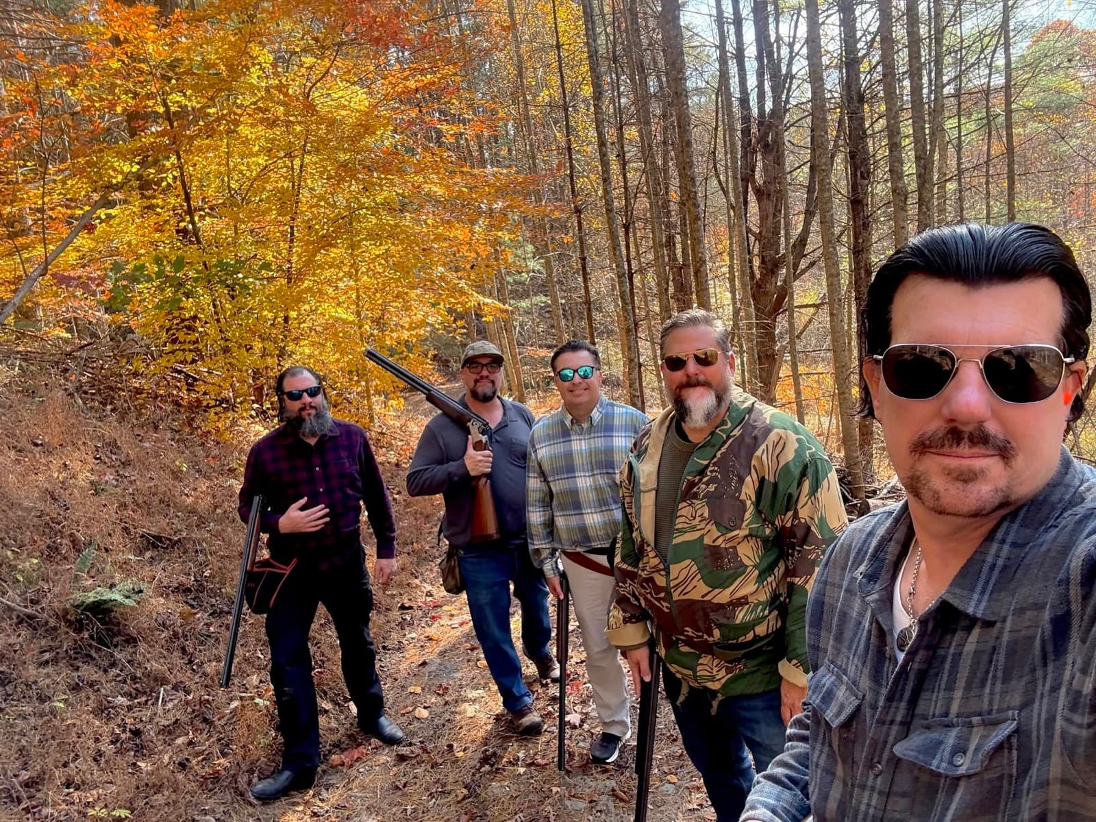 Chuck and RMH members together on a wooded trail during an autumn shooting outing.